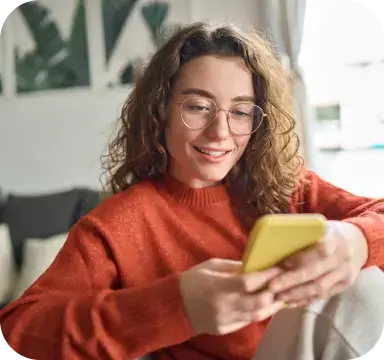 Woman in orange sweater with phone